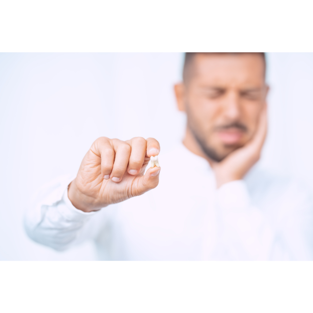Man holding a broken tooth and suffering from dental pain, highlighting the emergency repair services at The Denture Company in Nampa, Idaho.
